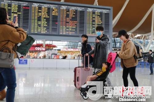 旅客帶著孩子前往辦票柜臺(tái)辦理登機(jī)手續(xù)?！∫罅⑶?攝