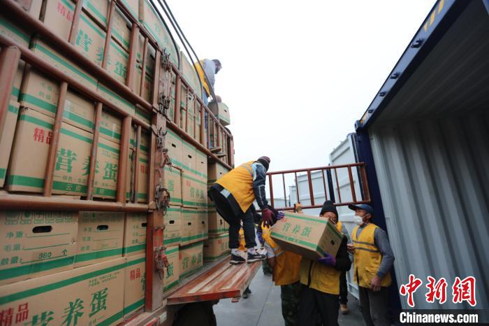 圖為鐵路裝卸作業(yè)人員正在將云南特色農(nóng)產(chǎn)品裝入集裝箱?！詈?攝